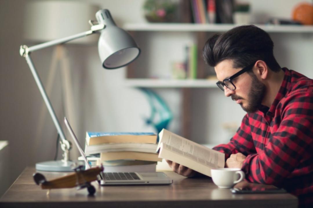 Moderne Lernumgebung mit aufgeschlagenem Notizbuch und Laptop auf hellem Schreibtisch