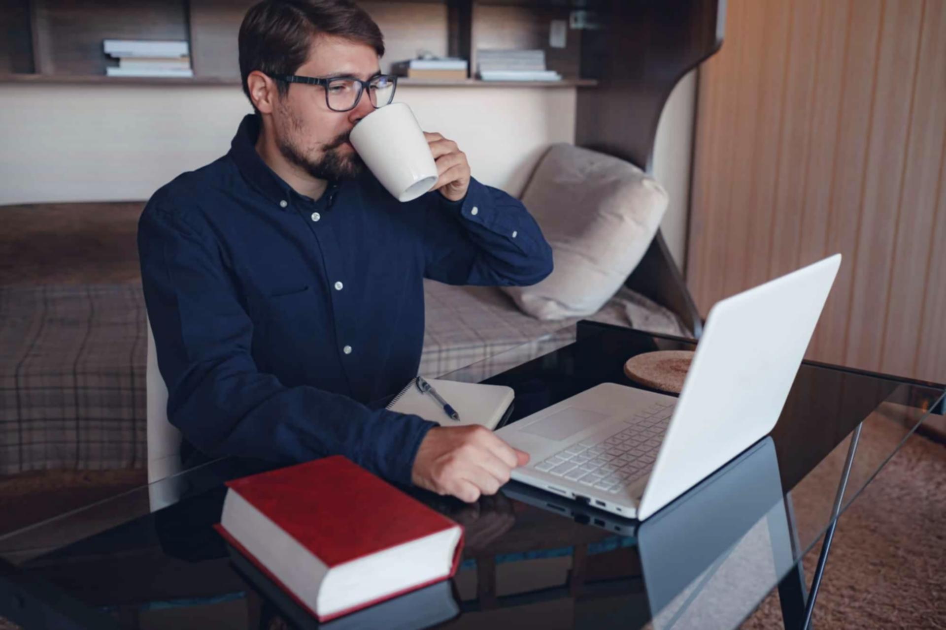 Person arbeitet konzentriert am Laptop in modernem Arbeitsumfeld